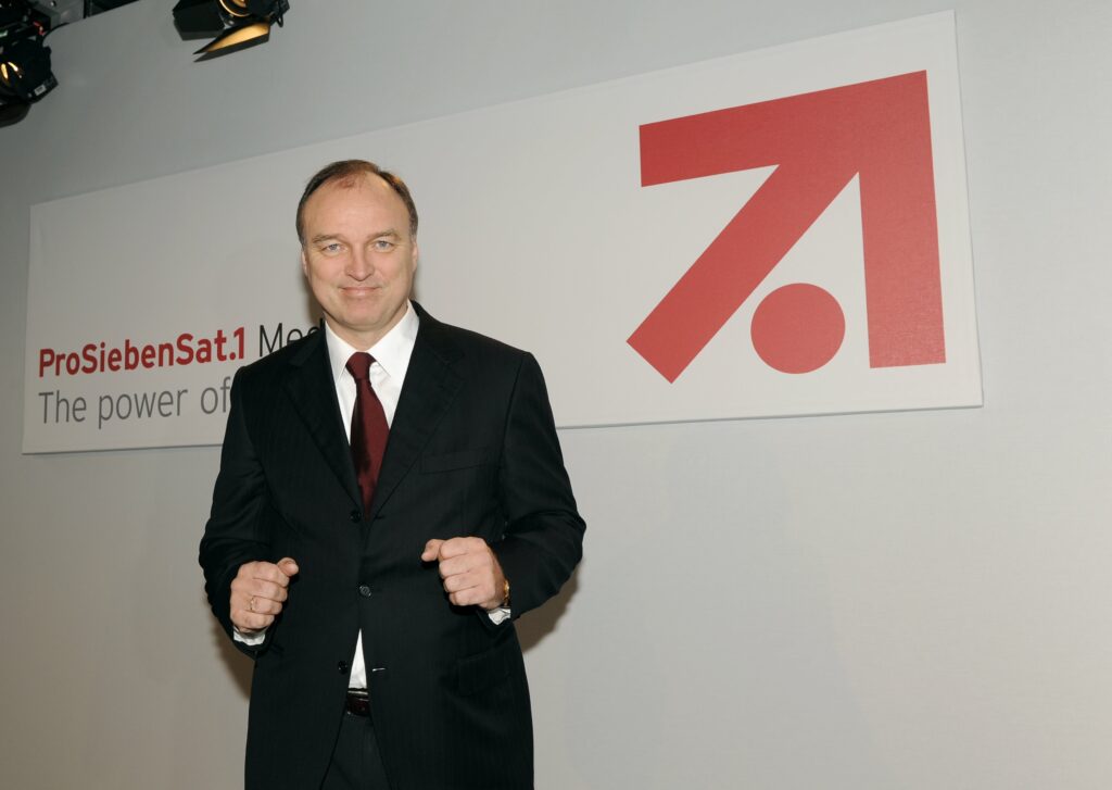 Thomas Ebeling steht vor dem Logo von ProSiebenSat.1 Media AG