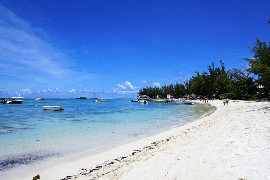 Ein hölzerner Steg führt ins türkisfarbene Wasser vor Mauritius, wo Prinz Harrys Ex heute mit ihrer Familie lebt – Foto: photosforyou / Pixabay