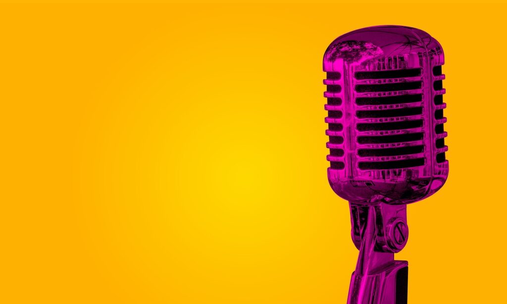 Ein Vintage-Mikrofon auf einer Bühne mit warmem Licht erinnert an die Disco-Ära von Gwen McCrae und Donna Summer – Foto: rahu / Pixabay