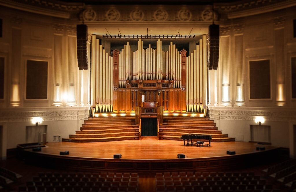 Ein leerer Konzertsaal mit Orchesterbühne symbolisiert die Live-Konzertreihe zur Filmmusik von Hans Zimmer – Foto: Desertrose7 / Pixabay