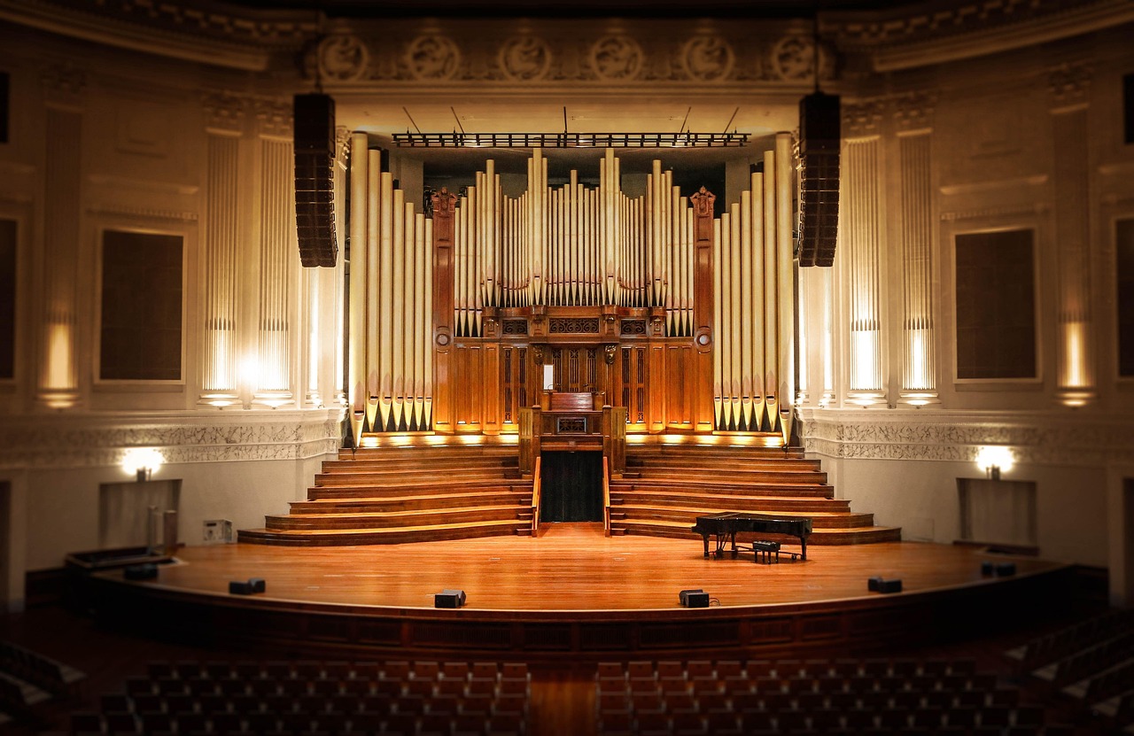 Ein leerer Konzertsaal mit Orchesterbühne symbolisiert die Live-Konzertreihe zur Filmmusik von Hans Zimmer – Foto: Desertrose7 / Pixabay