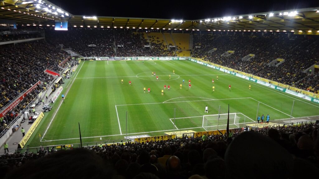 Ein leeres Fußballstadion bei Flutlicht steht sinnbildlich für die Rückkehr von Yusuf Demir zu seinem Jugendverein – Foto: meineresterampe / Pixabay